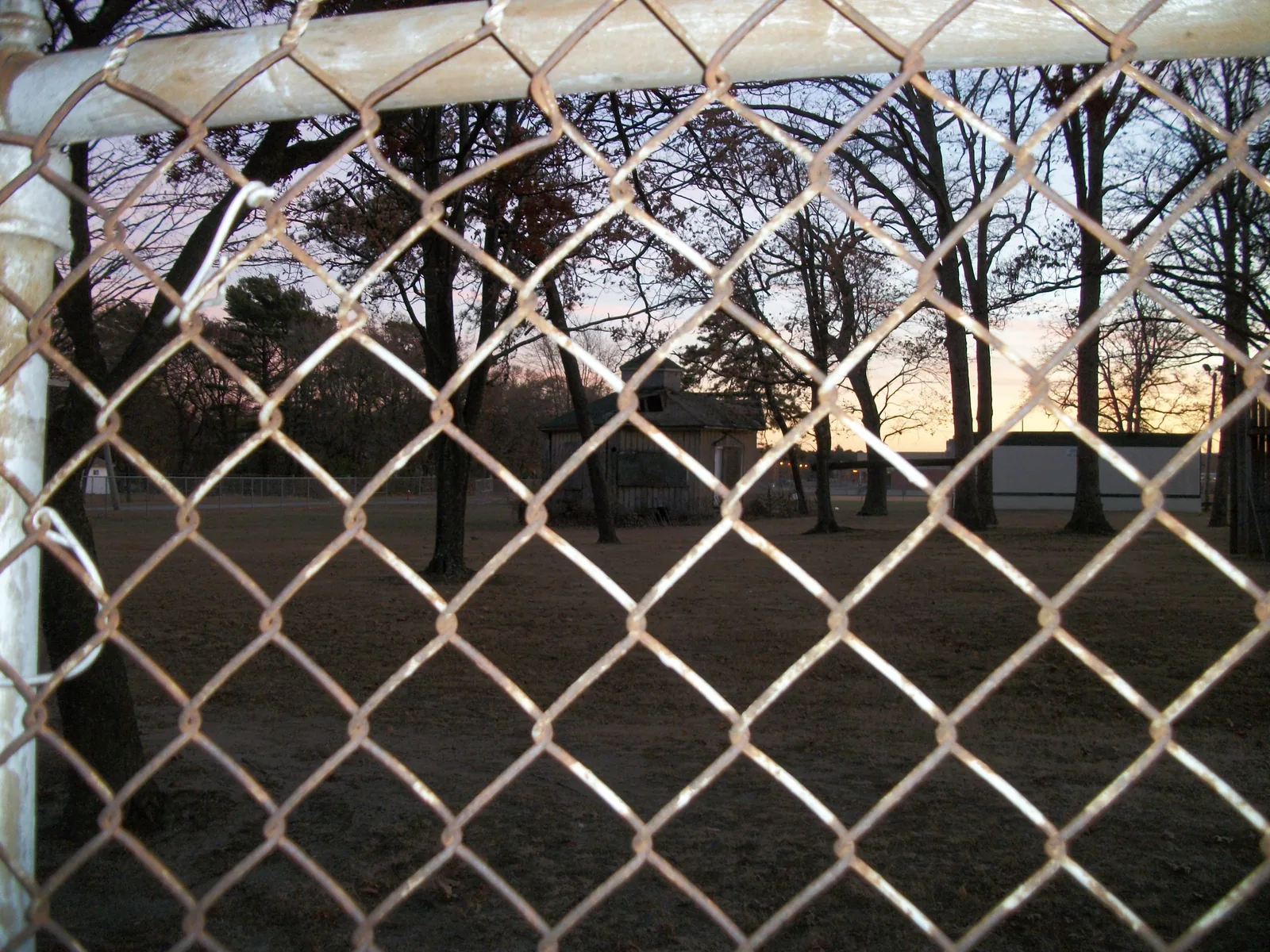 The historic Modern Times School, in Brentwood, New York, fully obstructed by the chain-link fence surrounding Brentwood High School.