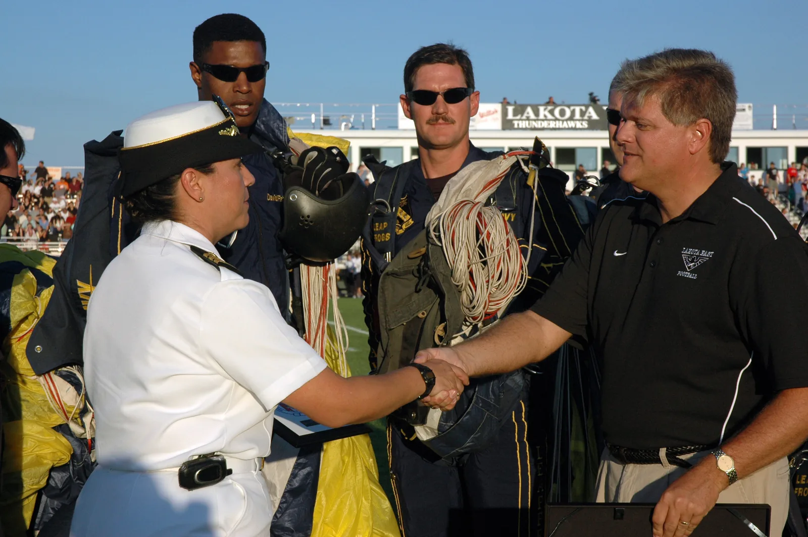 CINCINNATI (Aug. 31, 2007) - Navy Recruiting District Ohio executive officer Cmdr. Carol Kushmeir presents a command coin and plaque to Lakota East High School principal Keith Kline moments after the U.S. Navy Parachute Team‚ the Leap Frogs‚ completed a jump before the start of the football game between the Lakota East High School and Glen Este High School. The Leap Frogs visited throughout the Greater Cincinnati area along with Navy Band Great Lakes rock band, Horizon. Navy Weeks are designed t