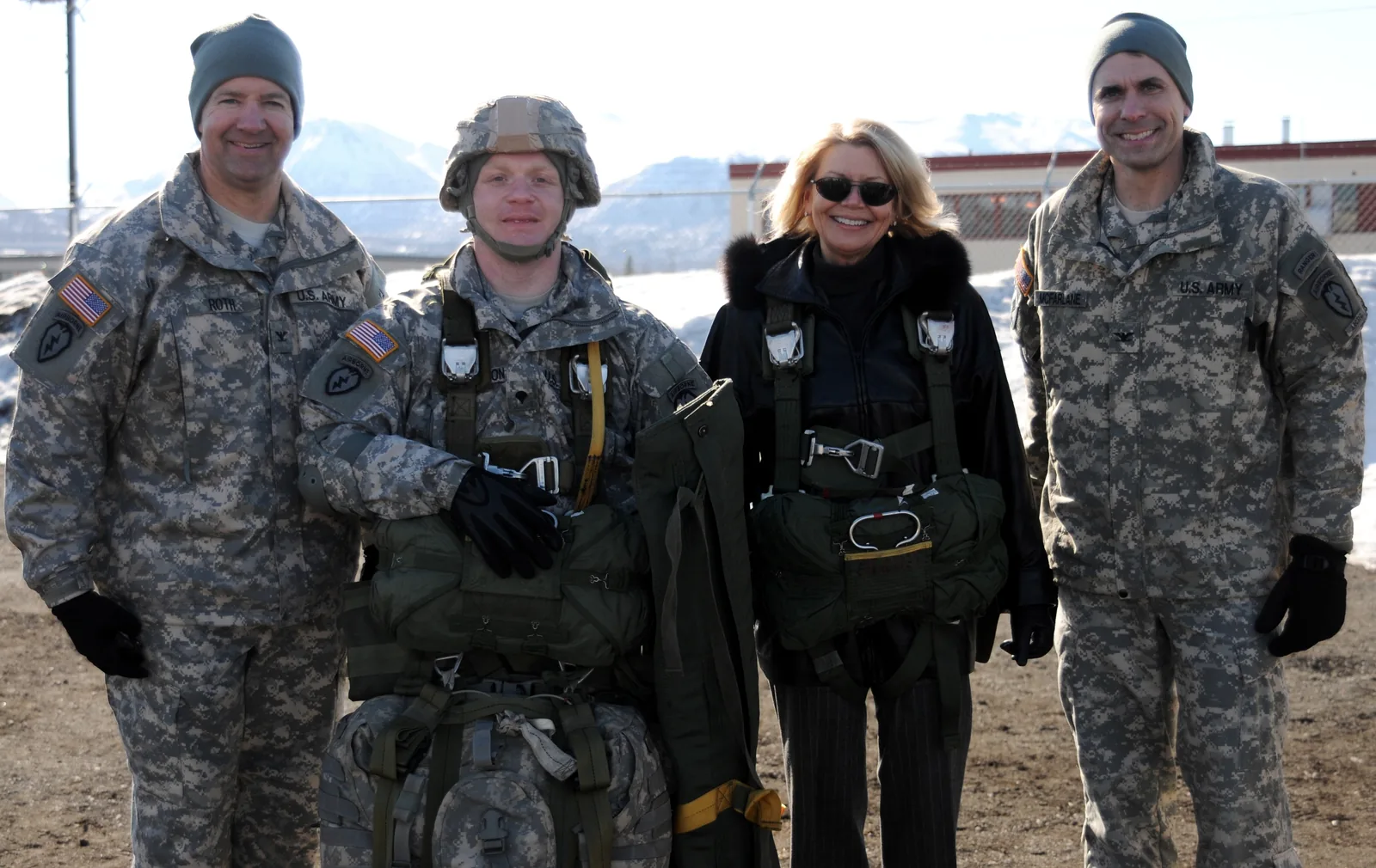 Sharon Anderson, Alaska's civilian aide to the secretary of the Army, poses for a photo after getting into an Army T10D parachute, with the Commanding Officer of the 2nd Engineer Brigade, U.S. Army Col. Thomas Roth, left, the commanding officer of the 4th Brigade combat Team (Airborne), 25th Infantry Division, Col. Matthew McFarlane, right, and another Soldier, during a School Partnership Program installation tour at Joint Base Elmendorf-Richardson, Alaska, April 25, 2013.  (U.S. Army photo by S