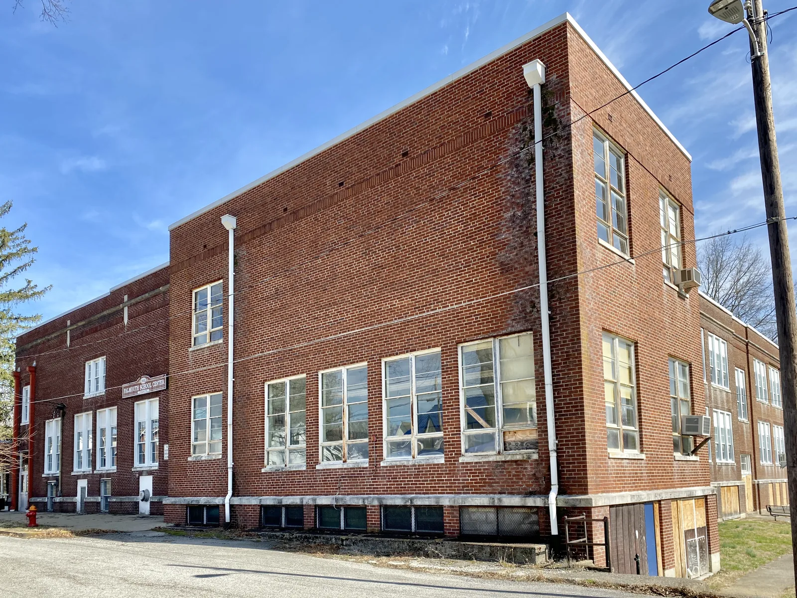 Built circa 1925 and expanded with an addition in the 1950s, this Classical Revival-style building was constructed to serve as a public school for Falmouth, Kentucky, replacing a previous school built in 1883.  The building is clad in red brick with replacement windows, limestone trim, a front door with a trim surround and doric pilasters, and a red brick addition at the southwest corner of the building with aluminum windows.  The building ceased to be utilized as a high school in 1968 when Pend